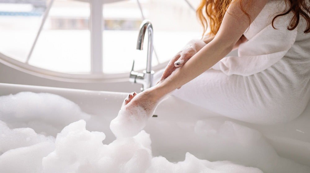 Someone dipping their hand in a bubbly bath