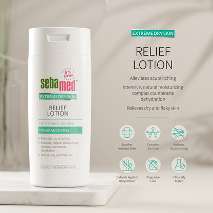 Sebamed Extreme Dry Skin Relief Lotion shown in a white bottle on a marble pedestal with product text and benefit icons on a soft beige background. 