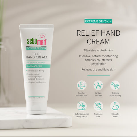 Sebamed Relief Hand Cream for extreme dry skin, shown in a white squeeze tube on a marble pedestal with product text and benefit icons on a soft beige background.