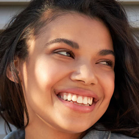 Close-up of a teenage woman smiling outdoors