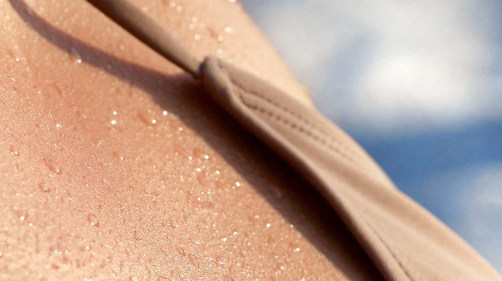 Close up of skin in the sun with water droplets